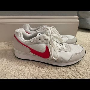 White / red Nike shoes.